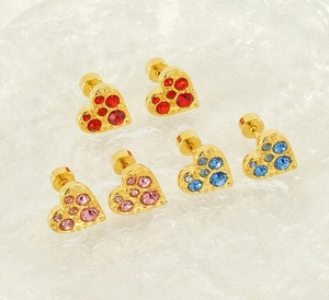 Dettaglio di orecchini a cuore dorati con strass scintillanti rossi, rosa e blu brillanti