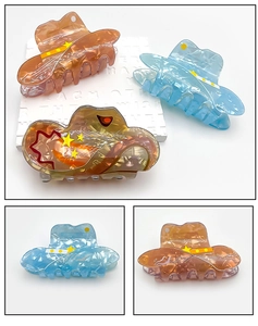 Detail of star-patterned acrylic hair claws in orange and blue gradient colors