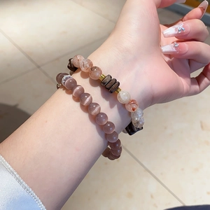 Detail of beaded bracelet with natural amethyst and rutilated quartz on female wrist