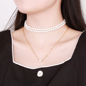 Close-up of double-layer white pearl choker and gold chain necklace set for women