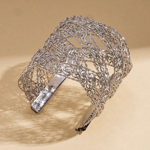Detail of silver woven mesh open cuff bracelet with intricate metallic net texture