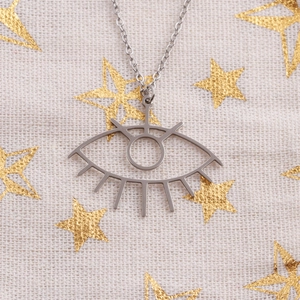 Collier en acier inoxydable argenté avec pendentif œil sur tissu beige à motifs étoiles