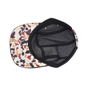 Internal detail of a 5-panel camper cap showing reinforced seams and multicolor print