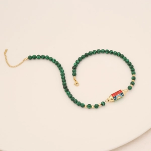 Detail of malachite beaded necklace with gold LOVE pendant and enamel eye motif