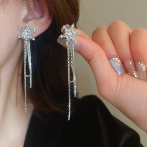 Close-up of snowflake pearl tassel earring with zircons worn on a model side profile
