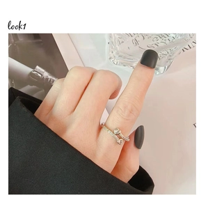 Detail of silver double heart open ring with pavé zircon setting worn on finger