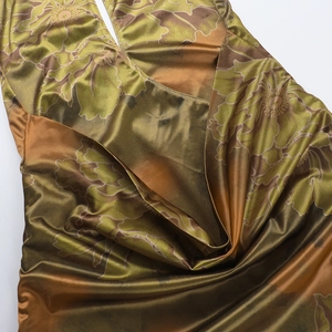 Detail view of smooth olive green satin fabric with vintage floral print and elegant drapes