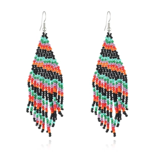 Handmade bohemian beaded tassel earrings with colorful Christmas pattern on white background