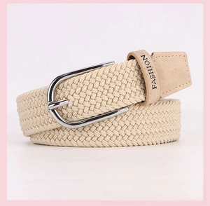 Close-up of beige woven elastic belt with silver metal buckle and fashion logo detail