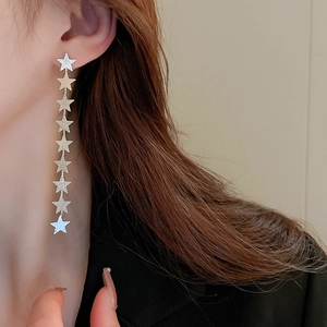 Close-up of silver long tassel earrings featuring nine linked stars on a female model