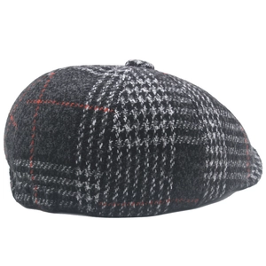 Close-up of deep grey and red plaid newsboy cap showing wool texture and top button