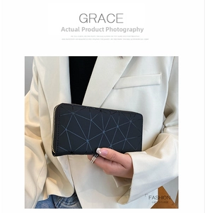 Detail of black geometric triangle pattern wallet with golden zipper and leather texture
