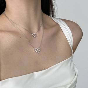 Close-up of double layered S925 silver heart necklaces worn on a model's neck