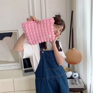 Detailed close-up of pink quilted bubble puffy canvas makeup bag with small Sozakka brand tag