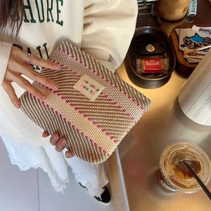 Macro detail of dopamine-style woven makeup bag in beige and brown with pink stripes