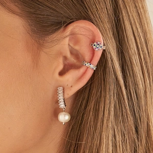 Macro detail of S925 sterling silver shell pearl earrings and diamond-set ear cuffs