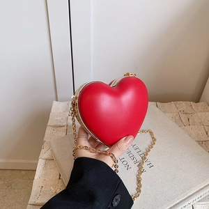 Chic red heart-shaped crossbody bag with gold chain strap for women in 2024 fashion