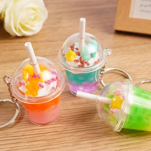 Creative bear ice cream cup keychain with gradient resin colors on a wooden table