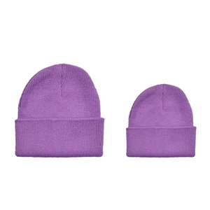 Flat lay of purple ribbed knit beanies in two sizes for matching parent and child sets