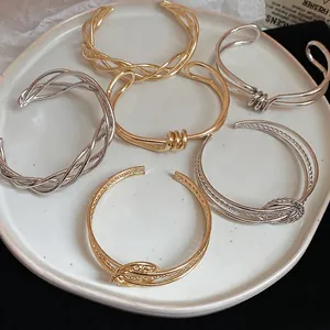 Minimalist twisted gold and silver cuff bracelet set with elegant knotted metal designs