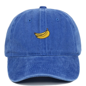 Close-up of a washed blue cotton baseball cap featuring detailed yellow banana embroidery