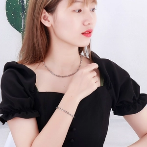 Ensemble collier et bracelet en chaîne trombone argentée porté par un mannequin