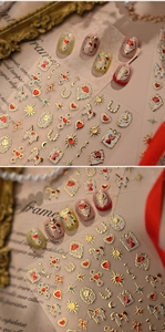 Macro detail of vintage baroque nail stickers with red roses and gold embossed patterns