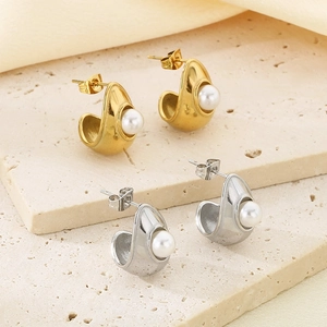 Detailed close-up of gold and silver semi-hoop earrings featuring inset pearls on stone