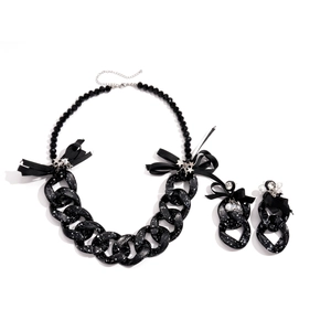 Acrylic black spotted chain necklace and bow earrings set with starry details