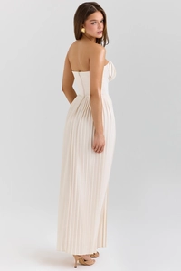 Detail of elegant cream strapless maxi dress with fine pleated fabric and a slim fit