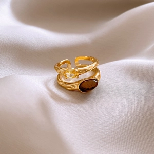 Detailed close-up of vintage gold rings with yellow drop-shaped and brown stones
