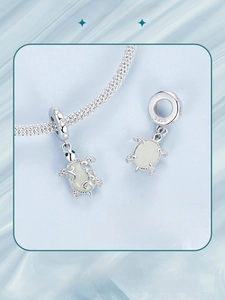 Detailed macro view of S925 sterling silver sea turtle charm with luminous stone inlay