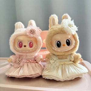 Close-up of pink and beige plush doll outfits with lace skirts and floral headpieces