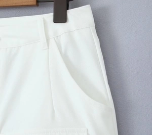 Detail shot of white low-waist cargo trousers featuring twill fabric and pocket stitching
