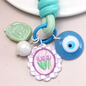 Détails du porte-clés avec œil bleu, tulipe violette et corde tressée bleu clair