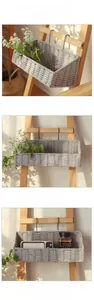 Detailed close-up of light gray woven cotton rope hanging basket with black metal hooks