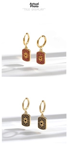 Detailed view of gold earrings with pavé rhinestones and a central sunburst motif