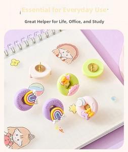 Macro shot of colorful macaron resin push pins with rainbow and donut shapes on a notebook