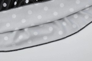Vue macro détaillée du tissu noir à pois blancs et couture de bordure de haute qualité