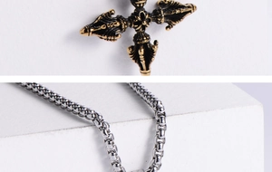 Detailed close-up of engraved cross pendant with contrasting gold and silver metal textures