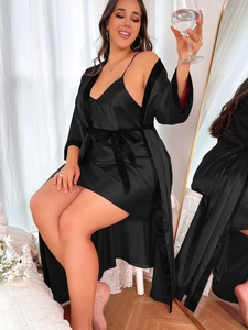 Detail of luxury black satin sleepwear set showing silky texture and lace trim