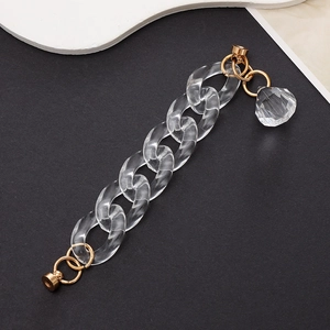 Macro view of transparent acrylic chain strap with gold ring and crystal pendant accessory