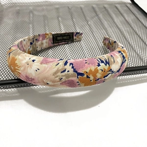 Detail of floral printed fabric headband featuring a woven HAND MADE label on inner lining