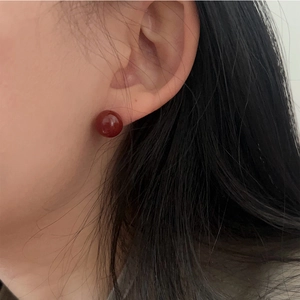 Minimalist red agate stud earrings in 925 sterling silver worn by a model
