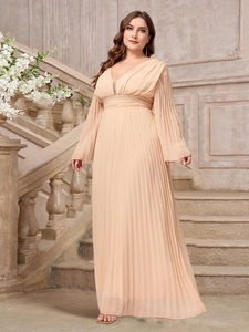 Detail of elegant champagne pleated V-neck evening gown on a grand stone staircase