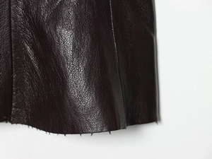 Gros plan sur la texture du cuir synthétique grainé marron foncé avec fini élégant