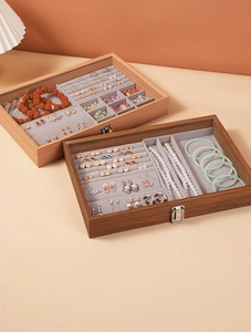 Detail of walnut wood jewelry box with velvet compartments and clear glass lid