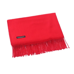 Solid red cashmere scarf with fringe details folded on a clean white background