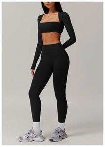Full view of black two-piece yoga set featuring a cropped long sleeve top and high waist leggings
