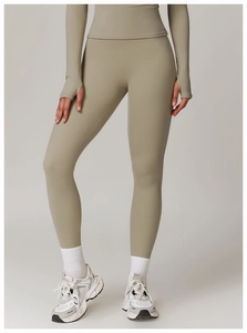 Detail of light brown high waist yoga pants with thumb hole long sleeve top and sneakers